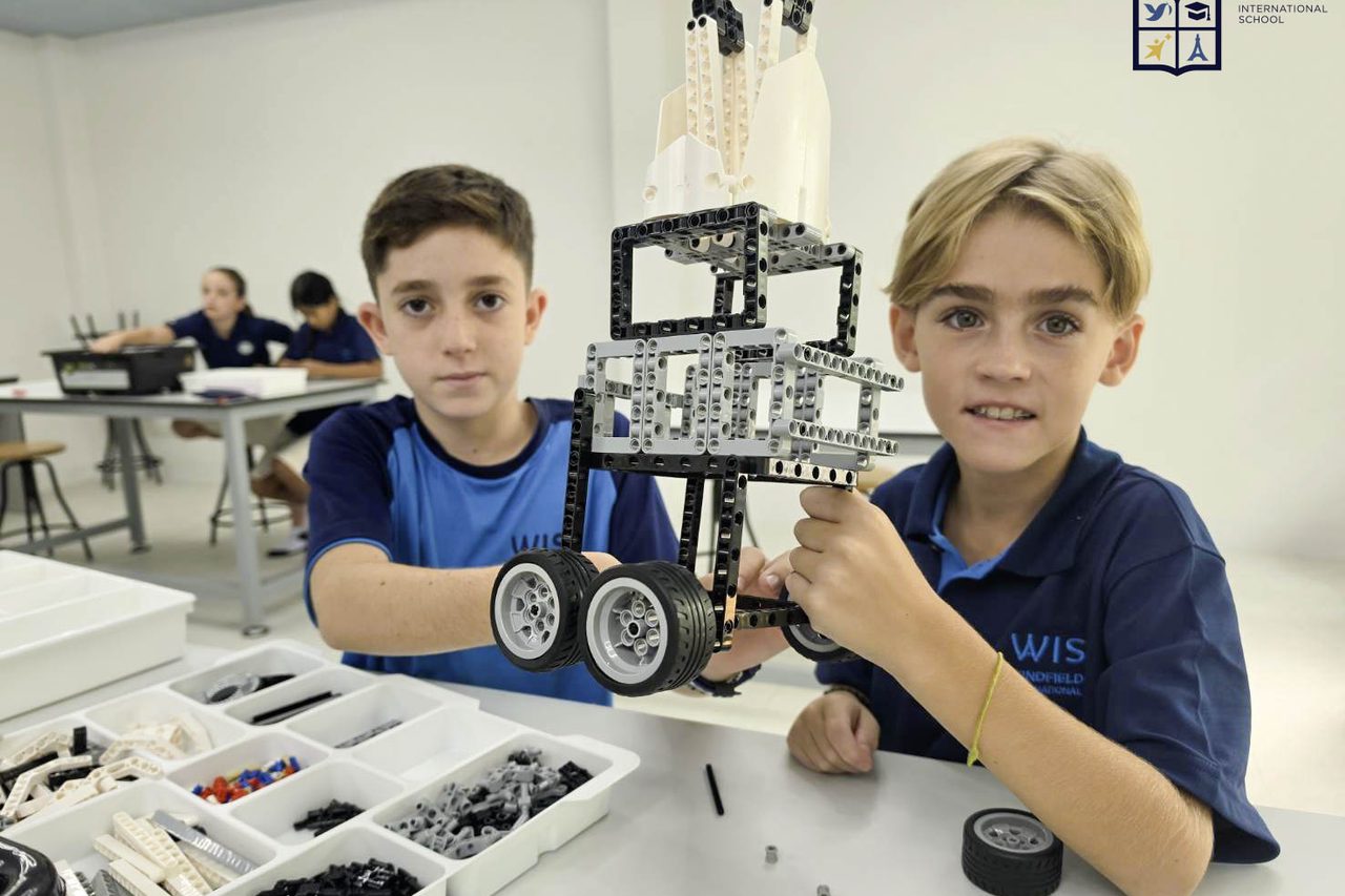 Two students showing the robot they built in the STEM lab. Two students showing the robot they built in the STEM lab.